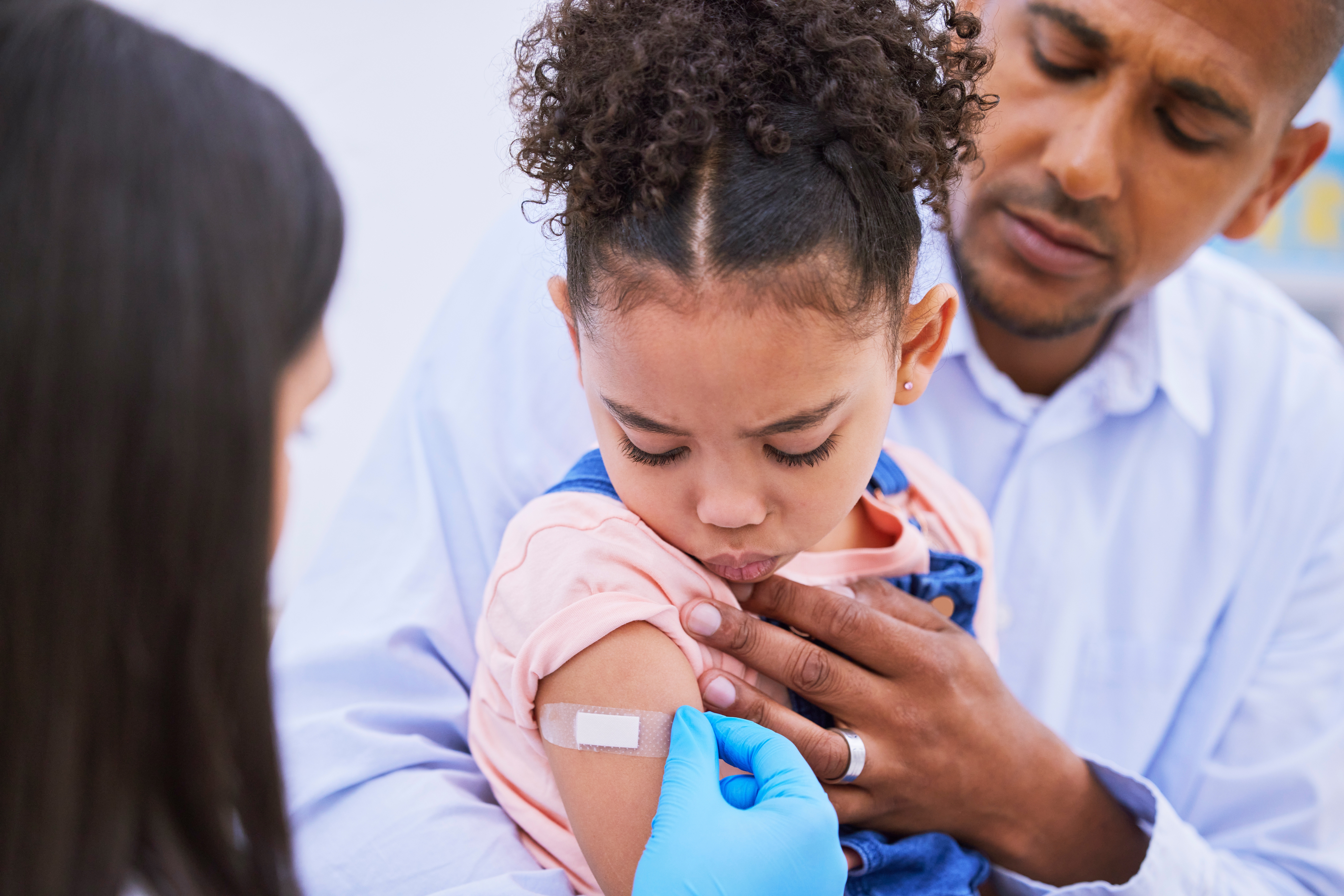 pediatrician,,dad,and,girl,with,plaster,for,vaccine,,flu,shot