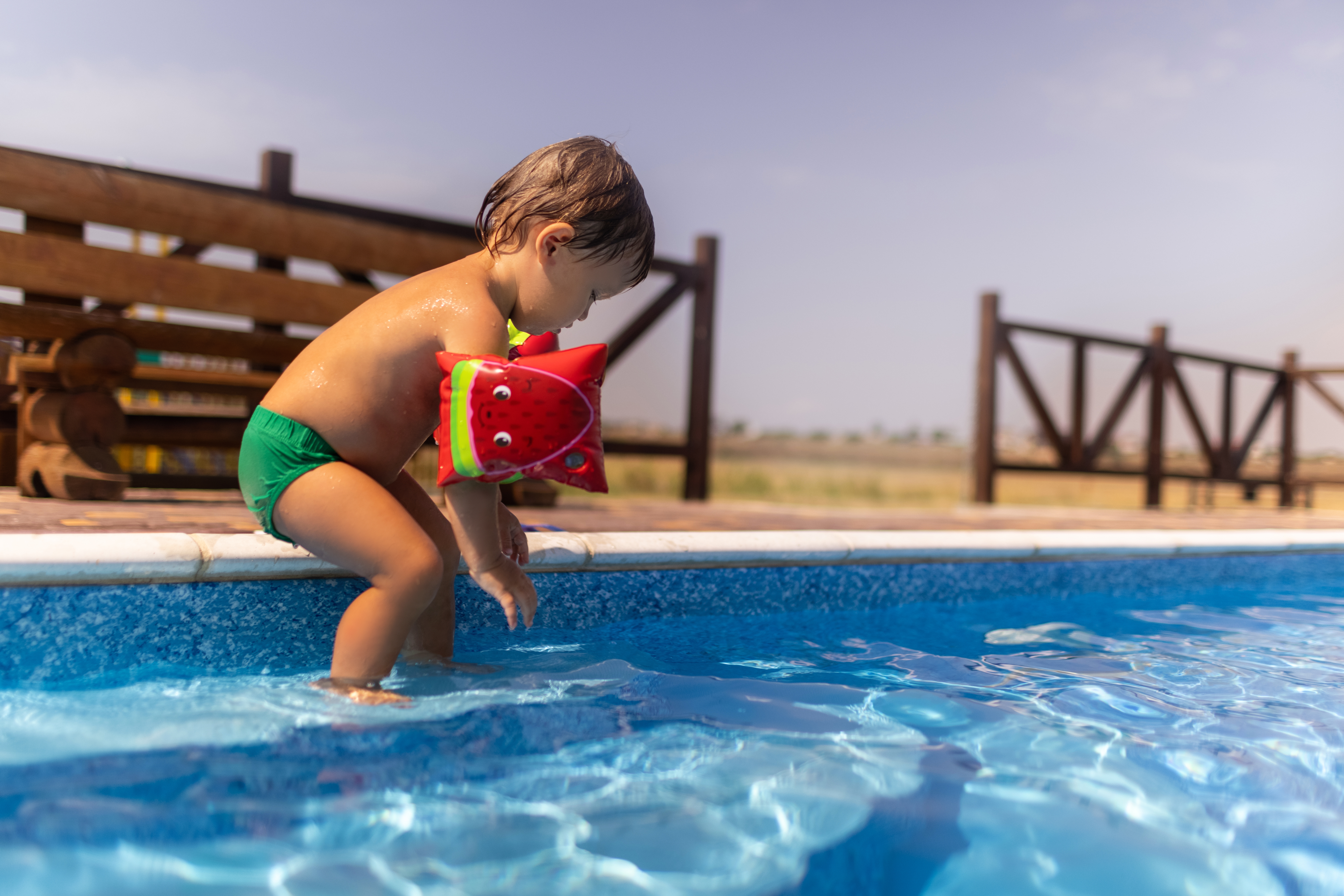 little,boy,with,bright,armbands,,playing,with,beach,colored,toys