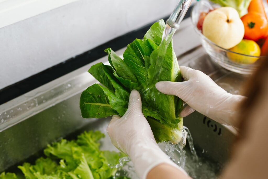 woman,washing,fresh,vegetables,at,kitchen,sink,,practicing,hygiene,and