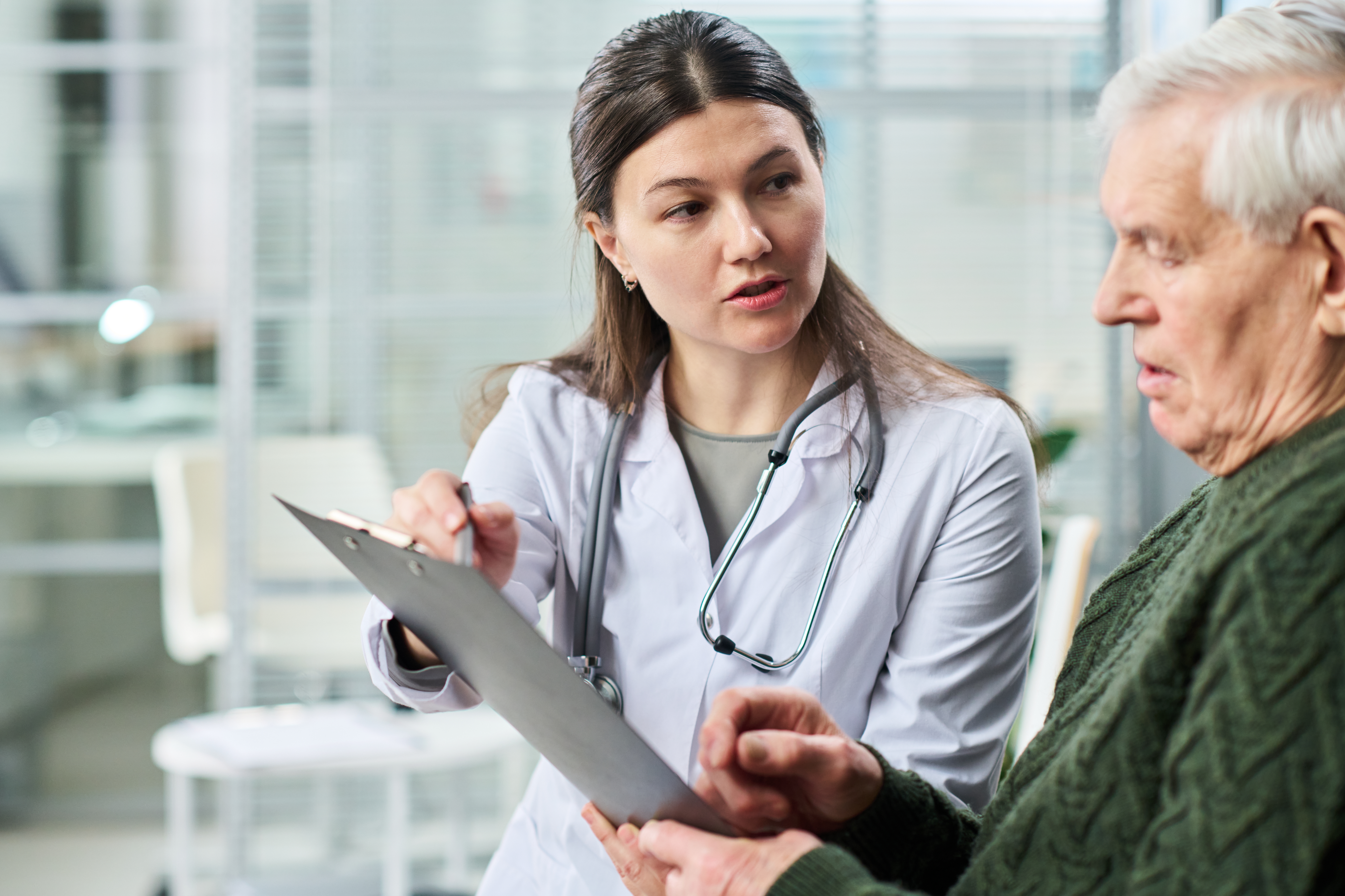 young,female,doctor,explaining,medical,information,to,senior,man,while