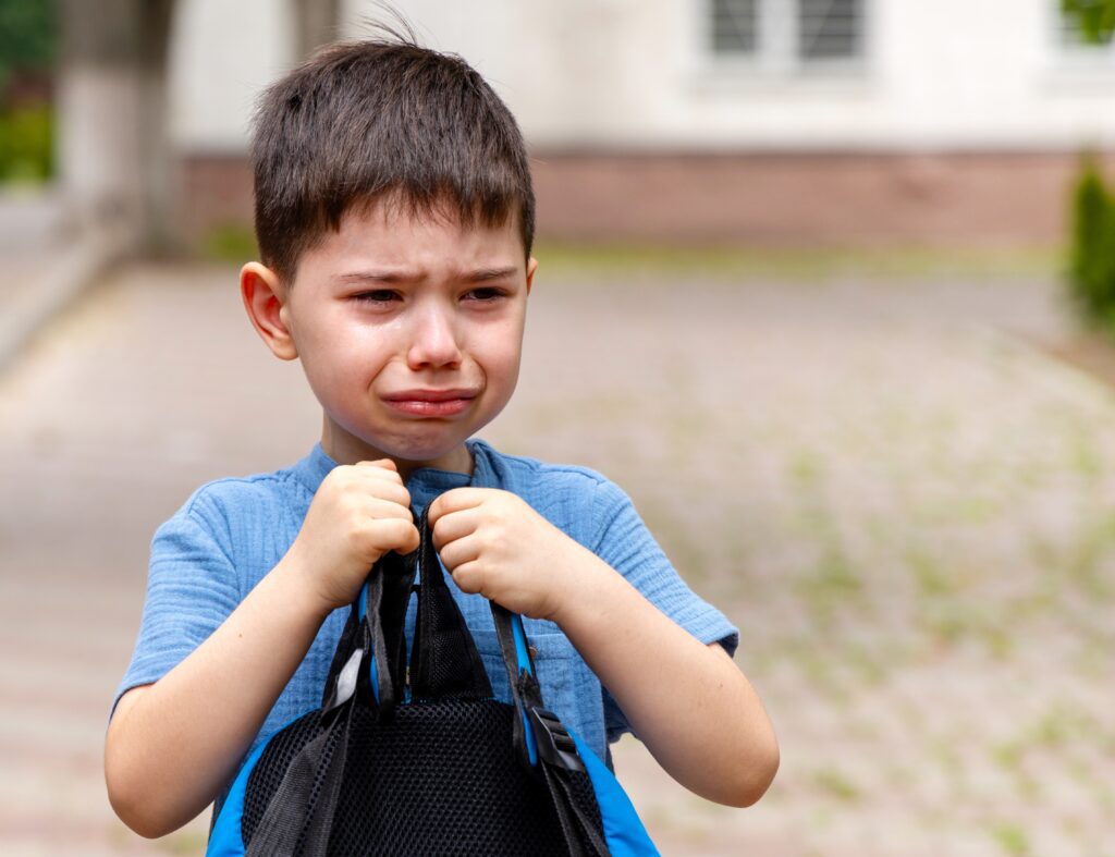 cute,preschooler,boy,crying,in,classroom,or,outside,with,backpack