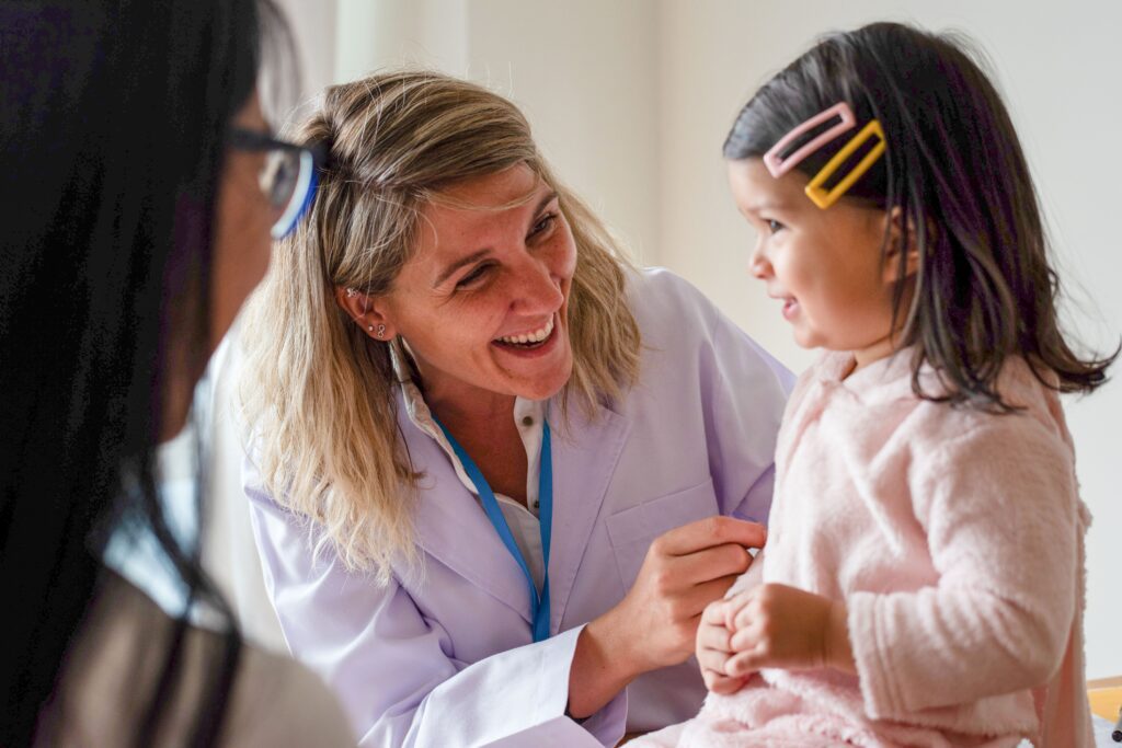 a,smiling,healthcare,professional,interacts,warmly,with,a,young,child,