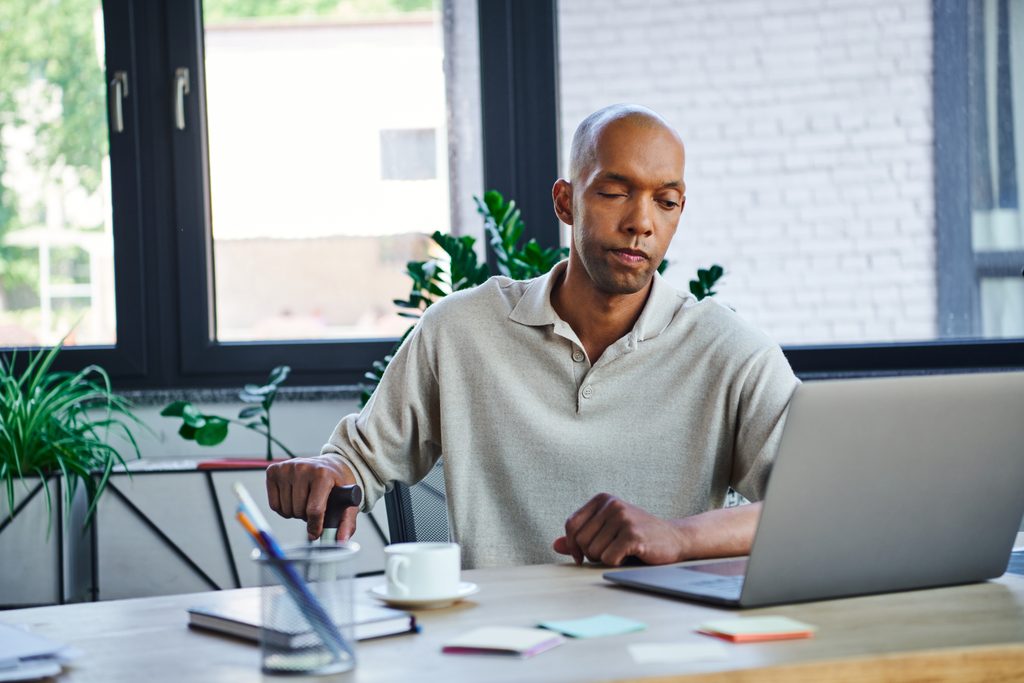 myasthenia,gravis,disease,,bold,african,american,businessman,using,laptop,,dark