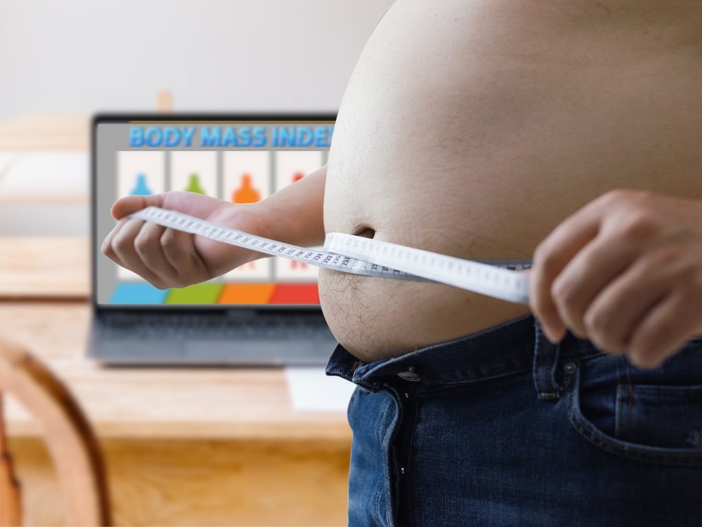 fat,man,check,out,his,body,fat,with,measuring,tape.