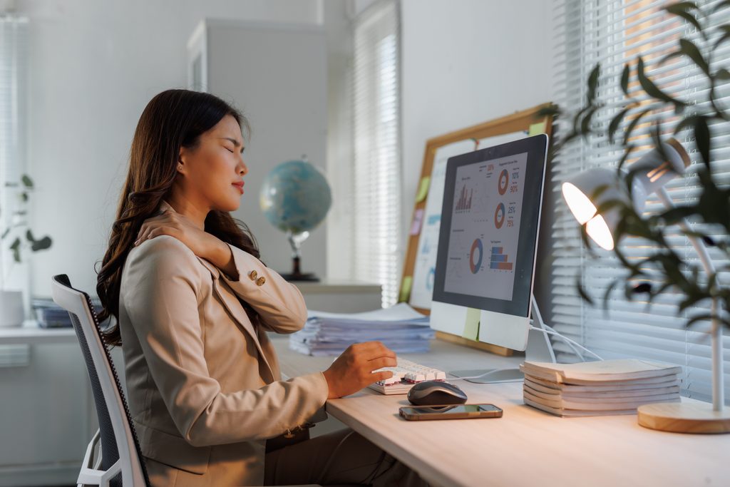 businesswoman,experiencing,stiff,neck,and,shoulder,pain,while,working,late