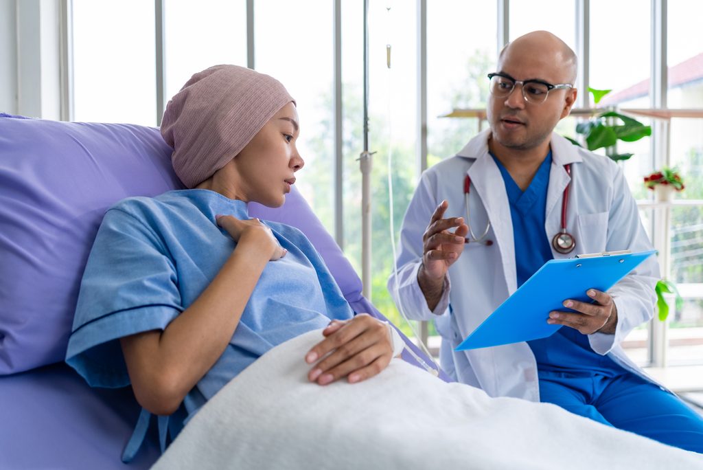 asian,woman,patient,describes,her,symptoms,to,an,oncologist,while