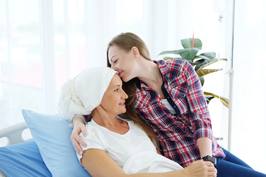 smiling,caucasian,daughter,with,elderly,mother,lying,on,a,hospital