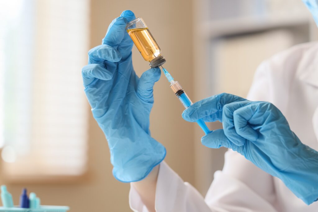 medical,professional,in,blue,gloves,preparing,syringe,with,vaccine,from